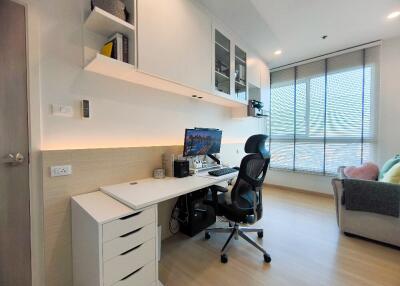 A modern home office with a desk, computer, and ergonomic chair