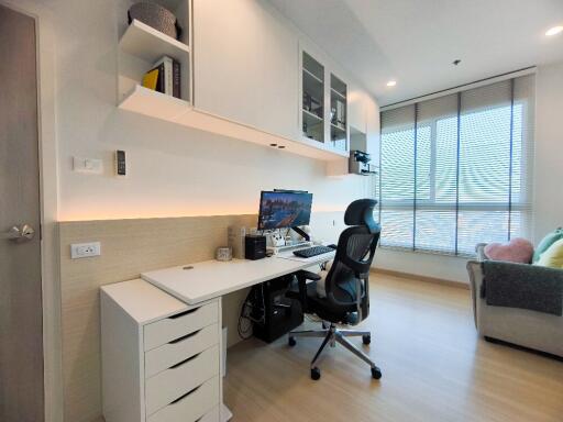 A modern home office with a desk, computer, and ergonomic chair