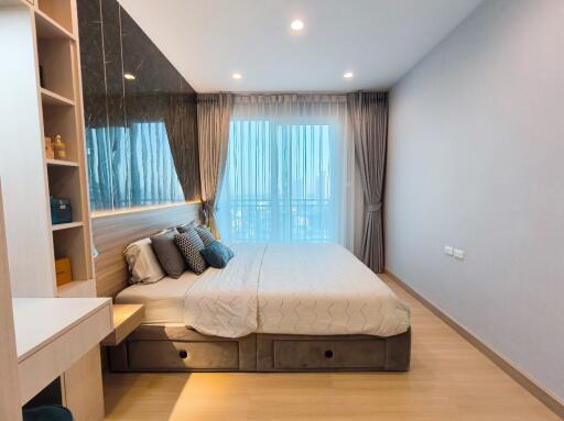 Modern bedroom with large window and elegant furnishings