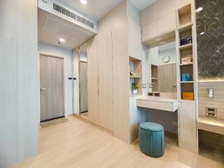 Bedroom with built-in storage, vanity area, and a door leading to the next room