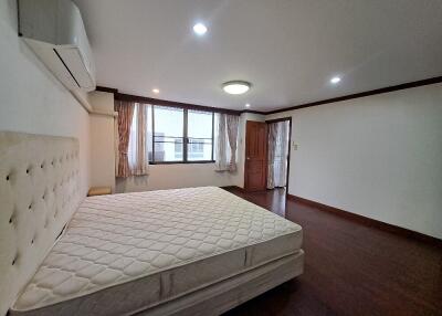 Spacious bedroom with a large window and air conditioning