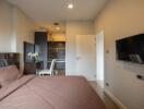 Modern bedroom with a desk area and wall-mounted TV