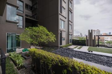 Modern apartment building exterior with landscaped garden and pool