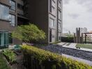 Modern apartment building exterior with landscaped garden and pool