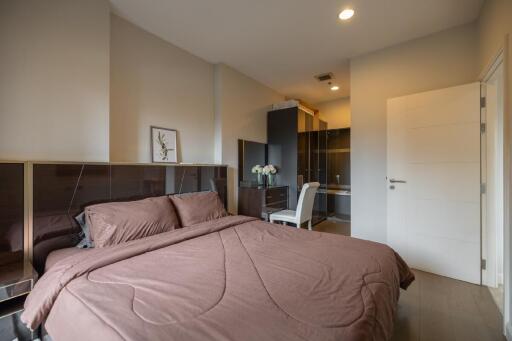 Bedroom with a brown bedspread, study desk, chair, and wardrobe