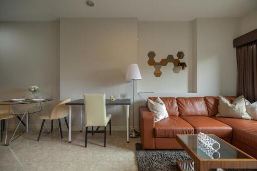 living room with brown leather sofa, dining area, and modern decor