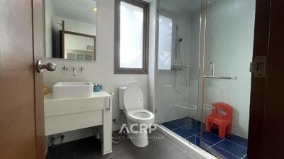 Modern bathroom with shower, sink, and toilet.