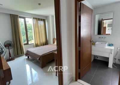 A bedroom with a view of an adjoining bathroom