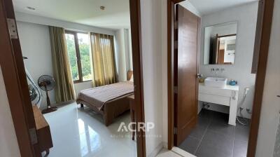 A bedroom with a view of an adjoining bathroom