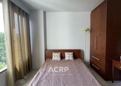 Bedroom with large window and wooden furniture