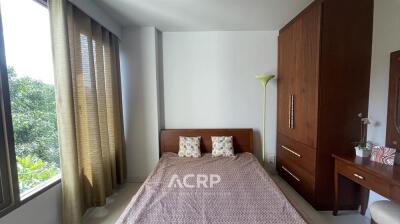 Bedroom with large window and wooden furniture