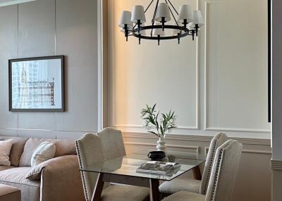 Modern living room and dining area with chandelier and wall art