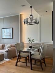 Modern living room and dining area with chandelier and wall art