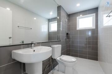 Modern bathroom with sink, toilet, and shower area