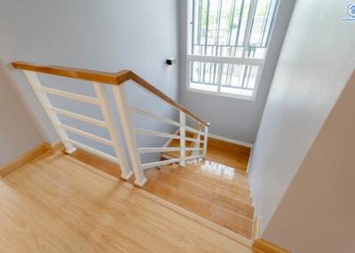 Well-lit staircase with wooden steps and white railing