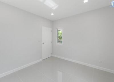 spacious empty bedroom with white door and small window