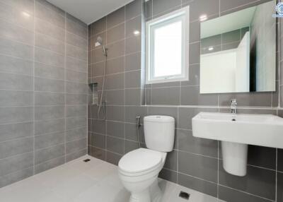 Modern bathroom with grey tiled walls and white fixtures