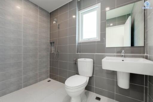 Modern bathroom with grey tiled walls and white fixtures