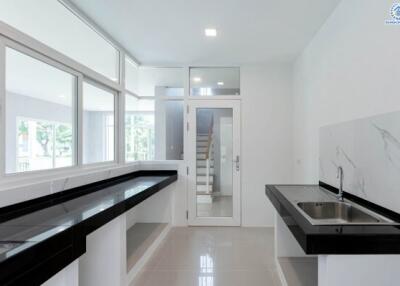 Modern kitchen with large windows and sleek black countertops