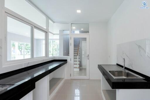 Modern kitchen with large windows and sleek black countertops