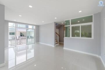 spacious living area with large windows and modern tile flooring