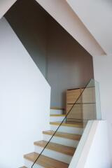 Modern staircase with wooden steps and glass railing