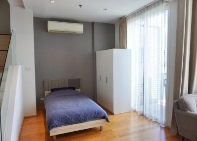 Bedroom with single bed, wardrobe, air conditioning unit, and large window with sheer curtains