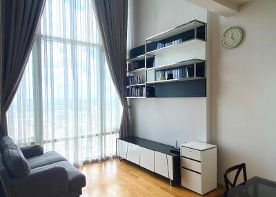 Modern living room with floor-to-ceiling windows, shelving unit, and sofa