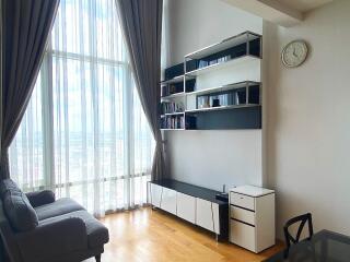 Modern living room with floor-to-ceiling windows, shelving unit, and sofa