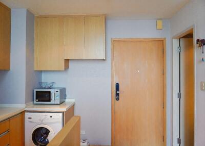 Modern kitchen with built-in cabinets, microwave, and washing machine