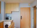 Modern kitchen with built-in cabinets, microwave, and washing machine