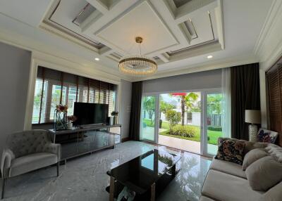 Elegant living room with a modern chandelier, large TV, and stylish furniture