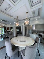 Dining area with round table and chairs, adjacent to open modern kitchen