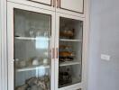 White cabinet with glass doors in kitchen