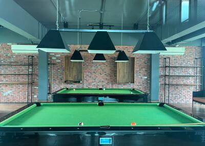 Billiard room with two tables and overhead lights