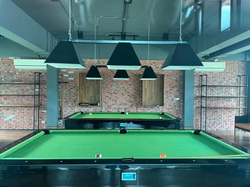 Billiard room with two tables and overhead lights