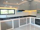 Modern kitchen with grey cabinets and built-in appliances