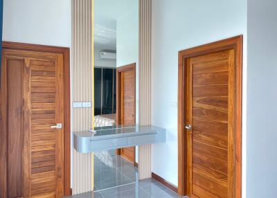 Modern hallway with wooden doors and wall-mounted mirror