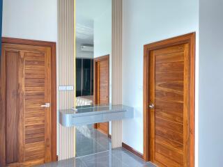 Modern hallway with wooden doors and wall-mounted mirror