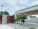 Covered carport area with tile flooring and potted plants