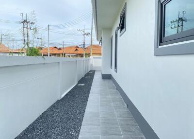 Side view of a house with a paved walkway and gravel area