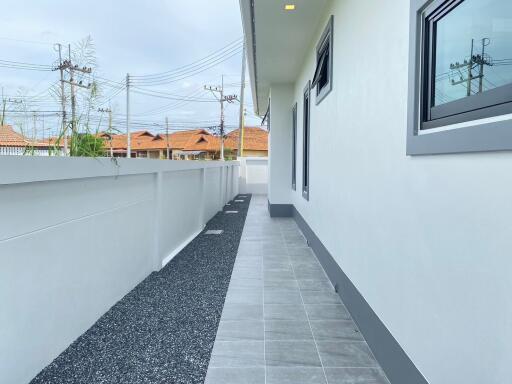 Side view of a house with a paved walkway and gravel area