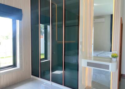 Modern bedroom with large window and glass door closets