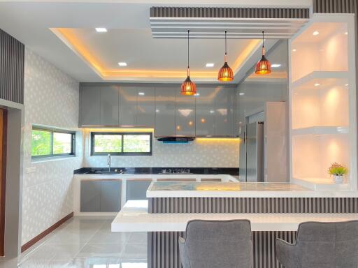 Modern kitchen with hanging lights and breakfast bar