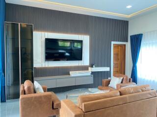 Modern living room with brown sofas and wall-mounted TV