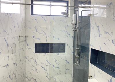 Modern bathroom with marble tiles and walk-in shower