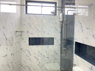 Modern bathroom with marble tiles and walk-in shower