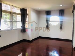 Spacious living room with wooden flooring and large windows