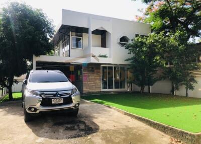 Front view of a modern two-story house with a car parked in the driveway