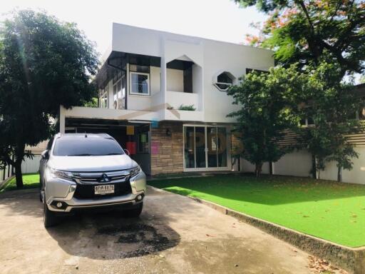 Front view of a modern two-story house with a car parked in the driveway